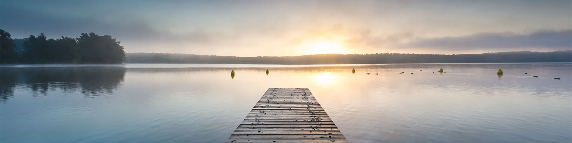 shutterstock_1102742372 Panorama eines Sees mit einem Steg bei Sonnenaufgang