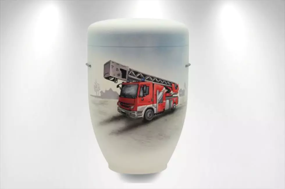 Weiße Urne mit Feuerwehrauto zur Beisetzung